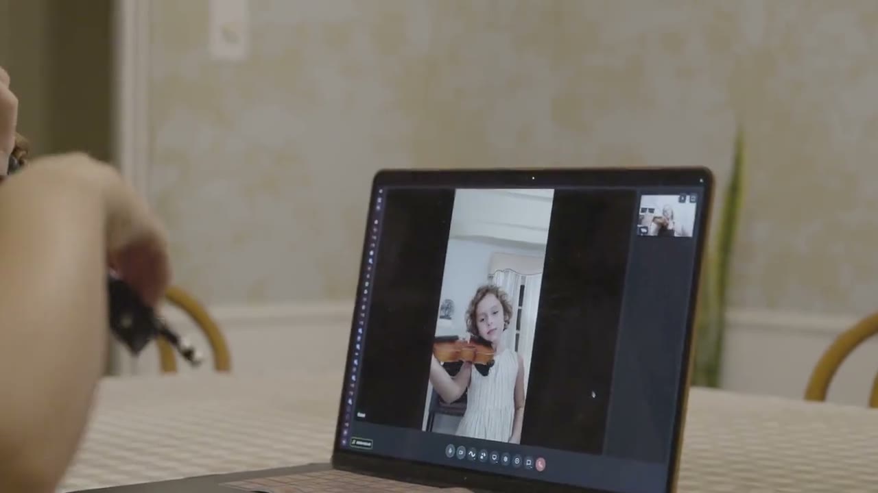 A violin lesson on a laptop, with the teacher on the screen